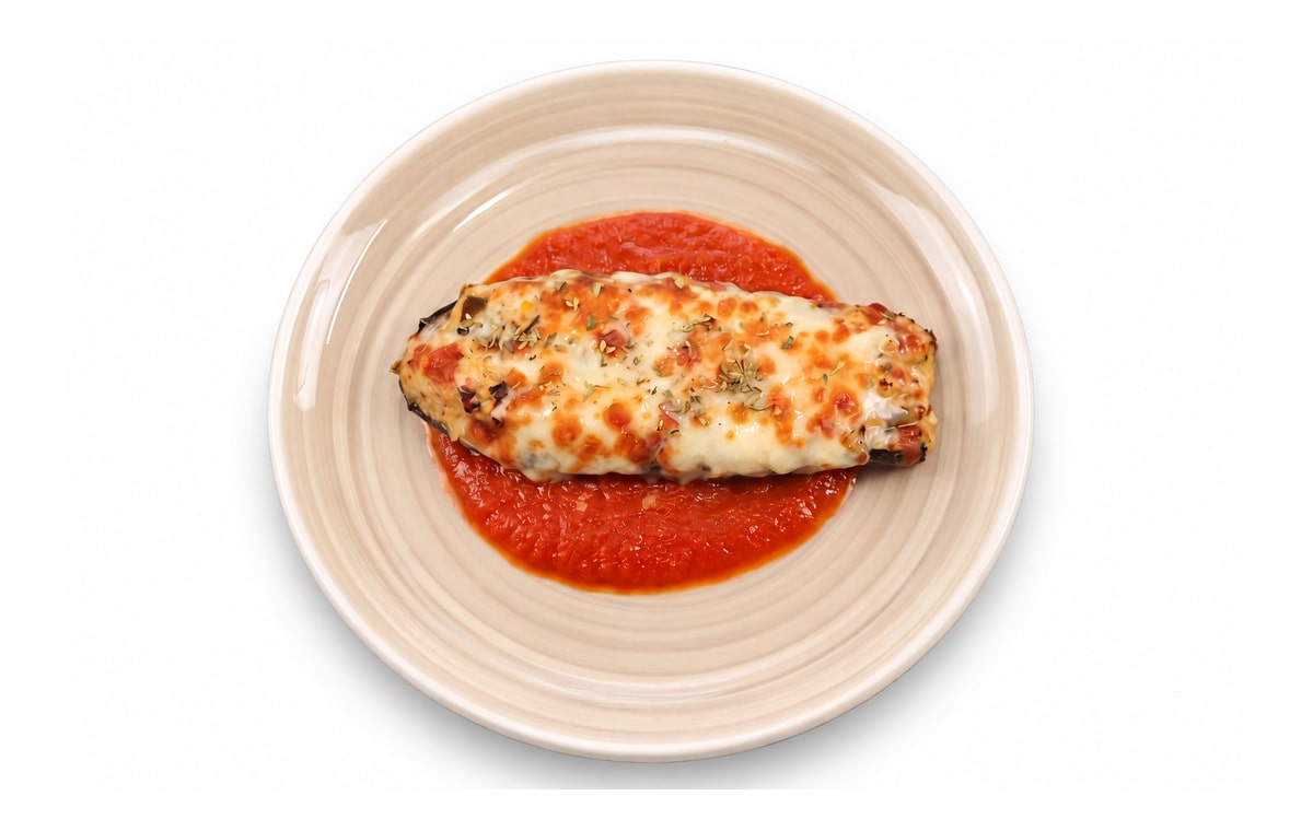 Calabacín relleno gratinado con mozzarella · Cocinatur. Fotografía retocada con IA para adaptar fondo y encuadre