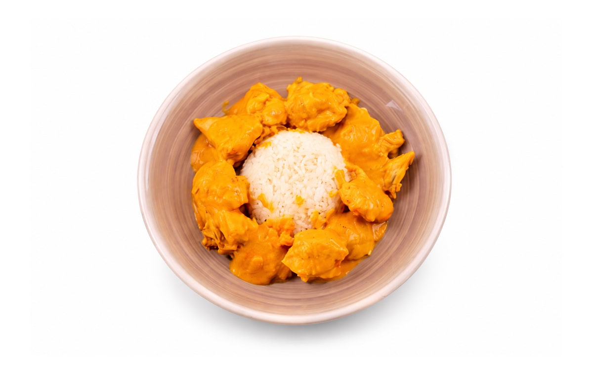 Pollo al curry · Cocinatur. Fotografía retocada con IA para adaptar fondo y encuadre